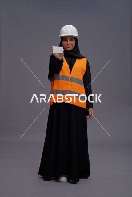 مهندسة سعودية تحمل بطاقة عمل بيضاء في الاستوديو