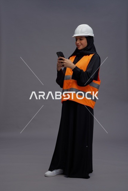 مهندسة سعودية تستخدم الجوال مرتدية سترة السلامة