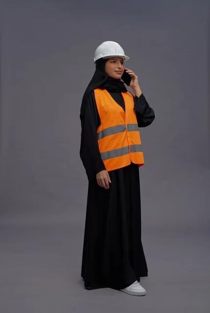 Saudi Female Engineer in Safety Vest on Mobile Phone