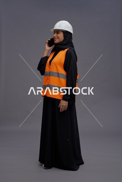 مهندسة سعودية بملابس السلامة تتحدث عبر الجوال