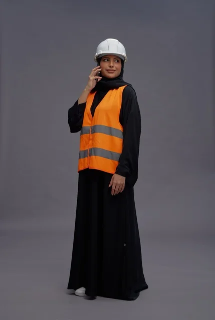 Saudi Female Engineer in Safety Vest on Mobile Phone