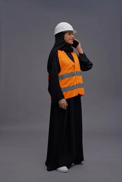 Saudi Female Engineer in Safety Vest Using Phone