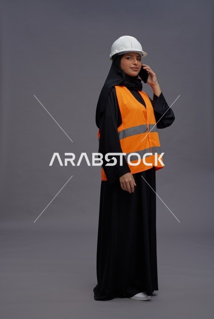 مهندسة سعودية بمعدات السلامة تتحدث بالهاتف