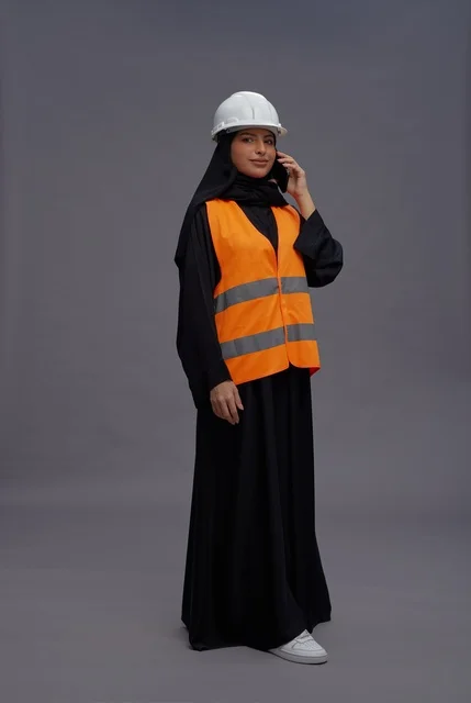 Arab Female Engineer in Safety Vest Using Smartphone
