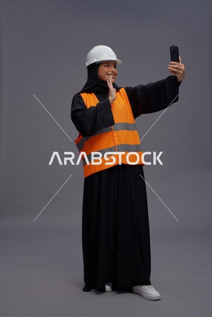مهندسة سعودية تستخدم الهاتف الذكي بملابس السلامة