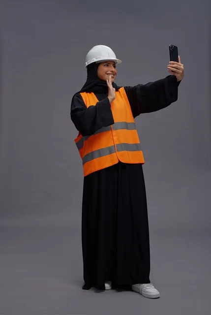 مهندسة سعودية تستخدم الهاتف الذكي بملابس السلامة