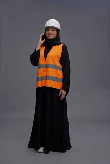 مهندسة سعودية بملابس السلامة تستخدم الهاتف الذكي
