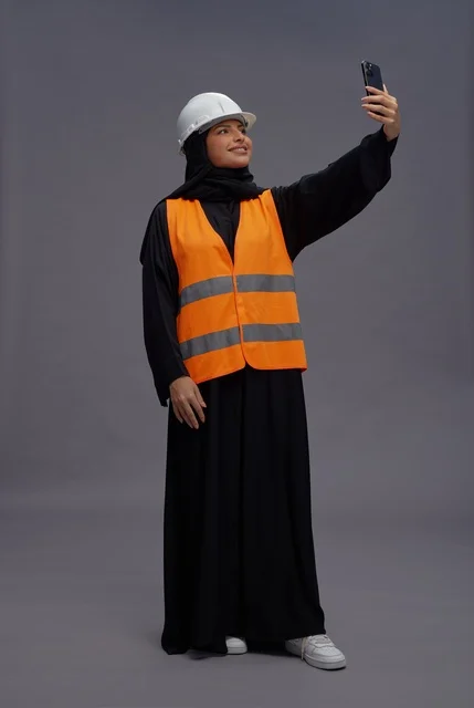 Saudi Woman Engineer in Safety Vest with Smartphone