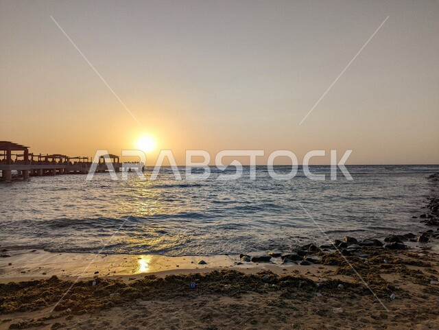 صورة جمالية لغروب الشمس على  شاطئ البحر، الواجهة البحرية أثناء الغروب، إنعكاس أشعة الشمس على المياه، أماكن ساحلية، أماكن السياحة