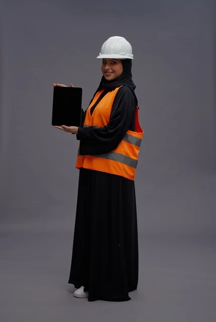 Saudi Female Engineer Holding Tablet in Safety Vest