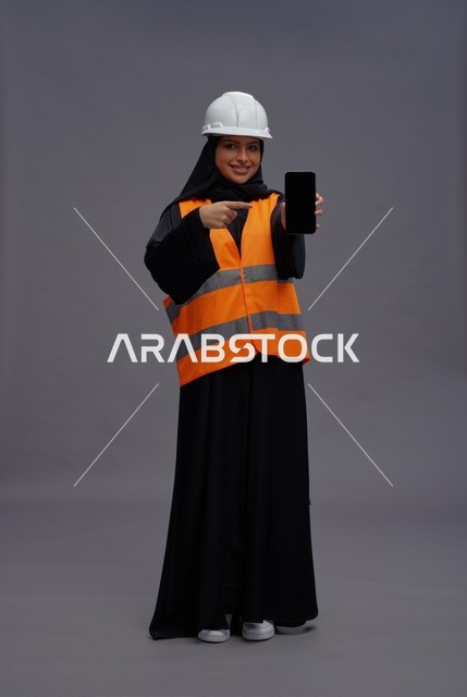 مهندسة سعودية تشير إلى شاشة هاتف ذكي فارغة