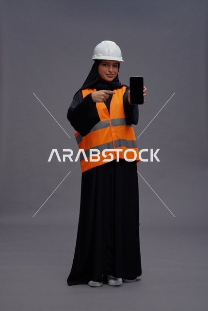 مهندسة سعودية تحمل هاتف ذكي بزي السلامة