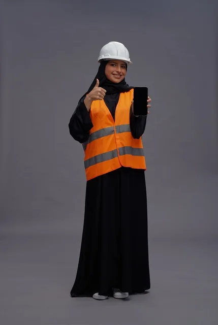 مهندسة سعودية تحمل هاتفاً ذكياً وتؤدي إيماءة الإعجاب