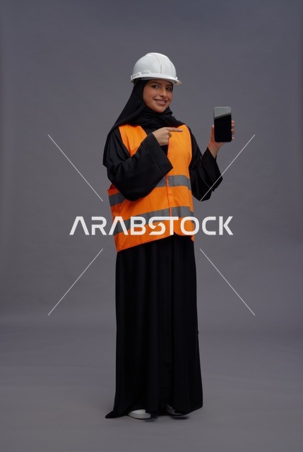 مهندسة سعودية تشير إلى هاتف ذكي في الاستوديو