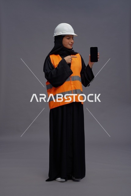 مهندسة عربية تحمل هاتف ذكي بشاشة فارغة
