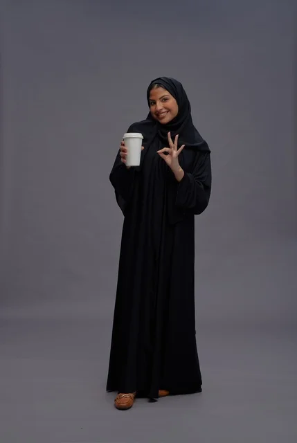 Saudi Woman in Black Abaya Holding Coffee Cup Studio Pose