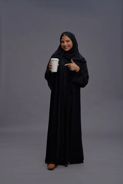 Saudi Woman in Abaya Holding Coffee Cup Studio Shot