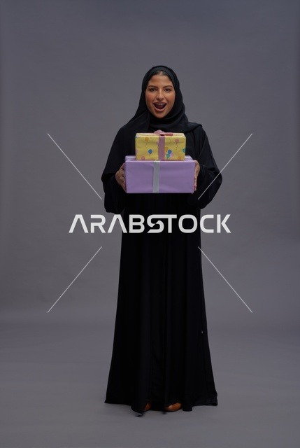 امرأة سعودية بعباية سوداء تحمل صناديق هدايا