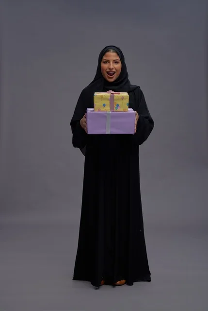 امرأة سعودية بعباية سوداء تحمل صناديق هدايا امرأة سعودية بعباية سوداء تحمل صناديق هدايا