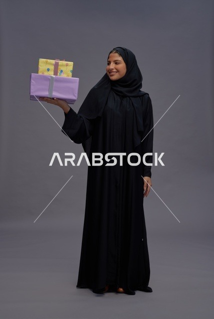 امرأة سعودية بالعباية السوداء تحمل هدايا