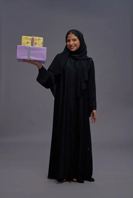 Saudi Woman in Black Abaya Holding Gift Boxes