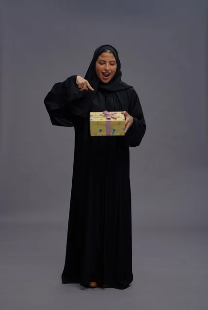 Saudi Woman in Black Abaya Holding a Yellow Gift Box