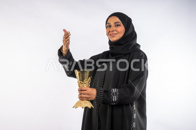بورتريه لإمرأه عربيه سعوديه خليجيه ترتدي العباءه السوداء تحمل حامل البخور ( المبخرة ) ، التطيب بالبخور والعود ، استخدام خشب العود في المناسبات والأعياد, العادات والتقاليد السعودية