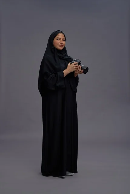Saudi Woman Holding Professional Camera in Studio