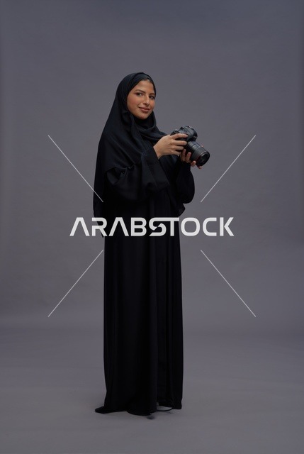 Saudi Woman Holding Professional Camera in Studio