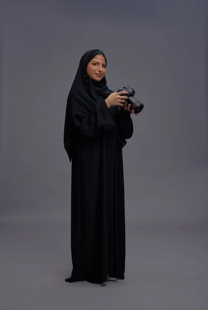 Saudi Woman Holding Professional Camera in Studio