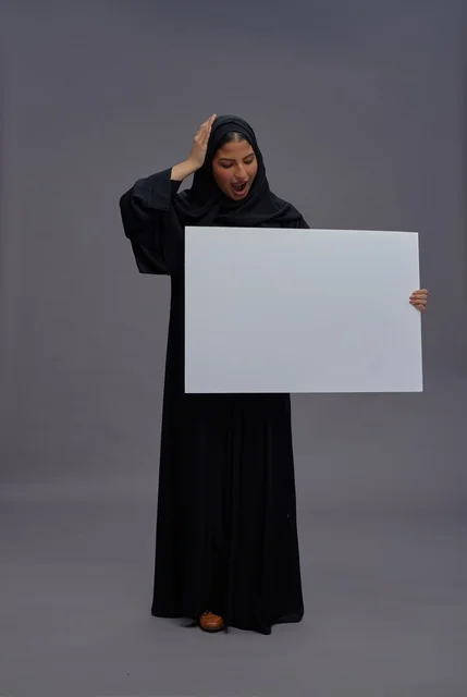 Surprised Saudi Woman in Abaya Holding Blank White Board