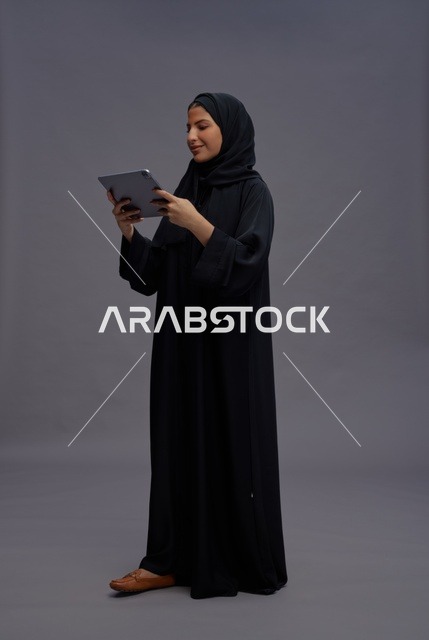امرأة سعودية تستخدم تابلت بالعباءة السوداء