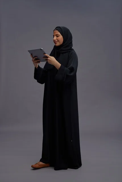 امرأة سعودية تستخدم تابلت بالعباءة السوداء