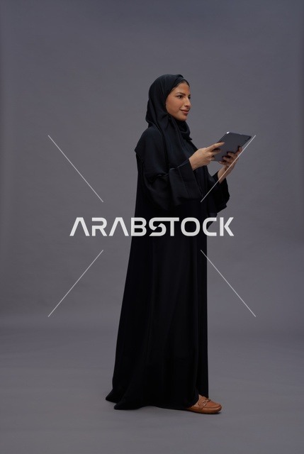 امرأة سعودية تستخدم جهازًا لوحيًا في الاستوديو