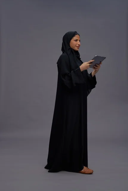Saudi Woman with Tablet on Grey Background