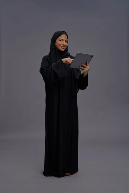 امرأة سعودية بالعباءة السوداء تستخدم جهاز لوحي في الاستوديو امرأة سعودية بالعباءة السوداء تستخدم جهاز لوحي في الاستوديو