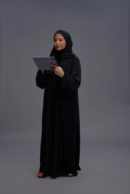 Saudi Woman Using Digital Tablet in Black Abaya