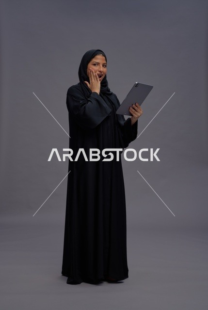 امرأة سعودية متفاجئة تستخدم جهازاً لوحياً في الاستوديو