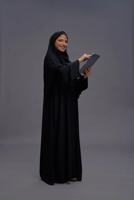 امرأة سعودية تستخدم جهاز لوحي بالعباءة السوداء