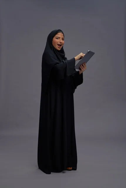 Saudi Woman Using Tablet on Grey Background