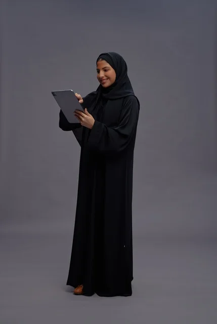 Saudi Woman in Black Abaya Using Digital Tablet Studio