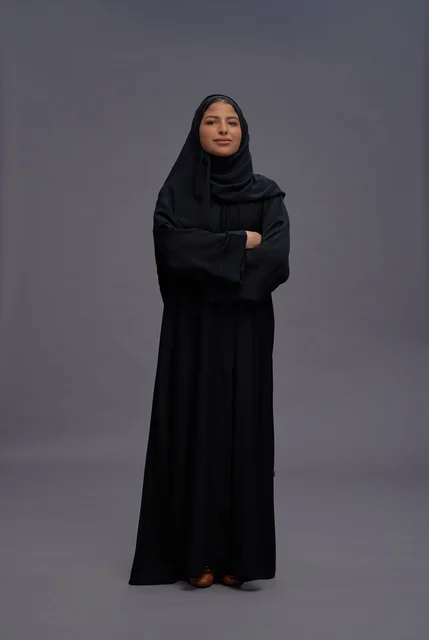 امرأة سعودية بعباءة سوداء ومكتوفة اليدين في استوديو