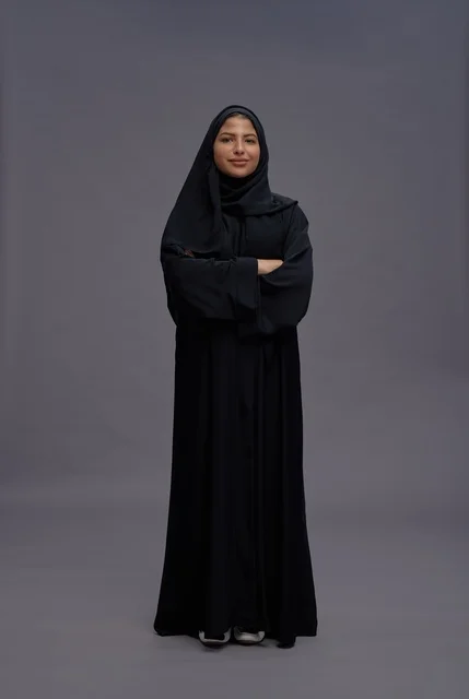امرأة سعودية بالعباءة السوداء تقف مكتوفة اليدين