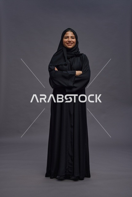 امرأة سعودية بالعباءة تقف بذراعين متقاطعتين