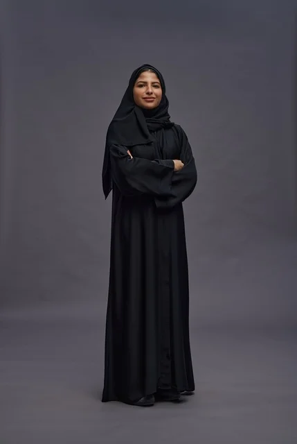 امرأة سعودية بالعباءة السوداء تقف في الاستوديو
