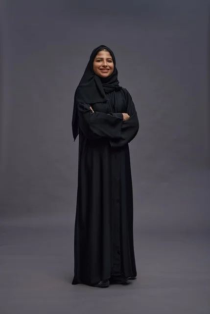 امرأة سعودية بالعباءة السوداء بوضعية واثقة في الاستوديو