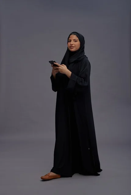 Saudi Woman in Black Abaya Using Smartphone in Studio