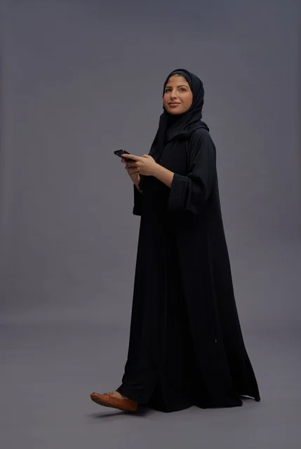 Saudi Woman in Black Abaya Using Smartphone