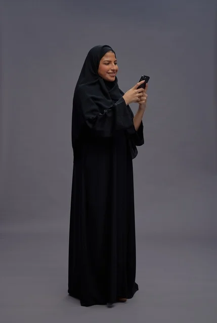 Saudi Woman in Black Abaya Using Smartphone in Studio