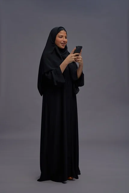 Saudi Woman in Black Abaya Using Smartphone